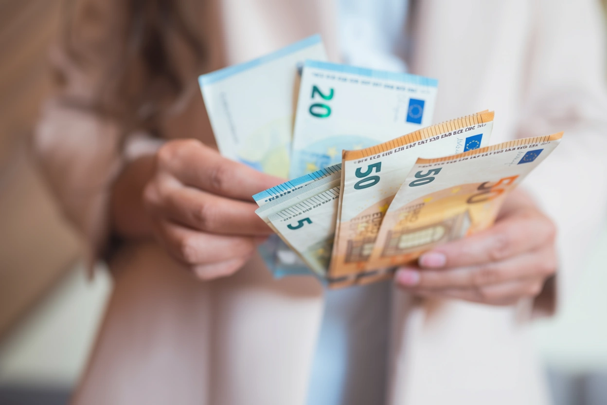 Unas manos sujetando unos billetes de euro